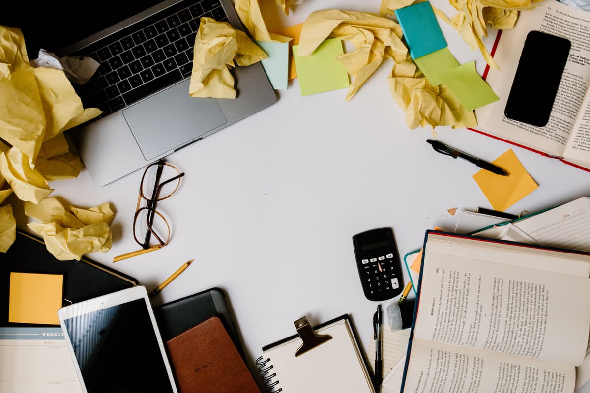 Close-up of an open textbook, a digital tablet, and a neatly organized desk.